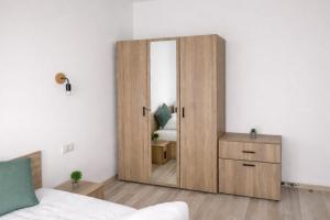 a bedroom with a large wooden door with a mirror at Hera Exclusive Stay 2 in Timişoara