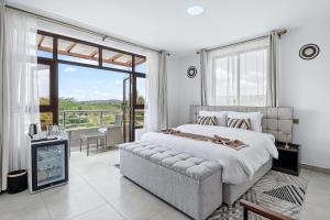 a bedroom with a large bed and a balcony at OSOTUA Villa 18 Home Hotel Nanyuki 7 Bedrooms 14 Guests in Nanyuki +20 photos