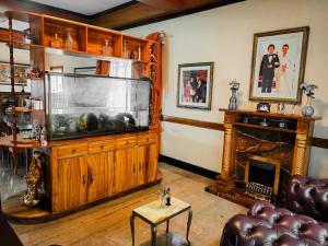 a living room with a large television and a fireplace at White House Benguet in Sablan