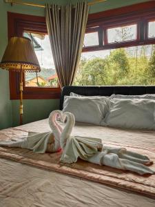 two swans laying on top of a bed at White House Benguet in Sablan +13 photos