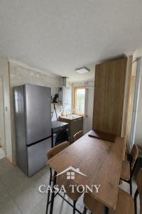 a kitchen with a wooden table and a refrigerator at Casa Tony Natales in Puerto Natales
