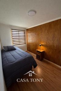 a bedroom with a bed and a table and a window at Casa Tony Natales in Puerto Natales