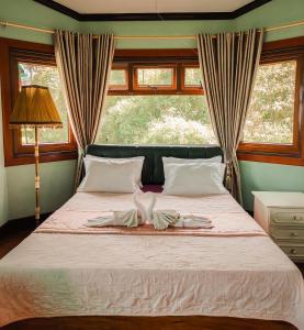 a bedroom with a bed with two towels on it at White House Benguet in Sablan