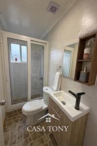 a bathroom with a toilet and a sink at Casa Tony Natales in Puerto Natales