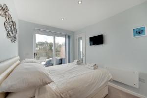 a white bedroom with a bed and a tv at 2 Bed in Brixham oc-bc157 in Brixham +14 photos