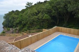 a swimming pool next to a wooden fence and the ocean at 2 Bed in Brixham oc-bc157 in Brixham
