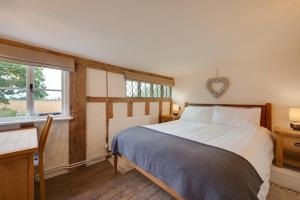 a bedroom with a bed and a desk and window at 2 Bed in Saxtead oc-pera in Saxtead