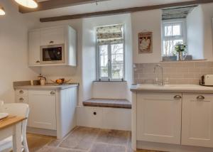 a kitchen with white cabinets and a sink and a window at 2 Bed in Hawes oc-ds042a in Hawes +8 photos