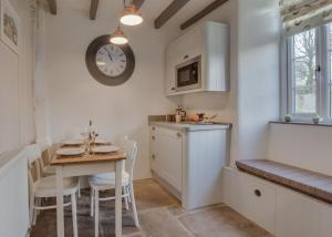 a kitchen with a table and a clock on the wall at 2 Bed in Hawes oc-ds042a in Hawes