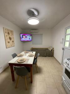 a dining room with a table and chairs and a couch at Cabaña 36 termas in Chajarí