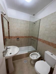 a bathroom with a toilet and a sink and a shower at Cabaña 36 termas in Chajarí