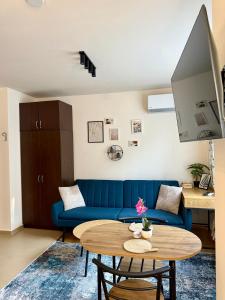 a living room with a blue couch and a table at Panorama Studio Home2Host in Bansko