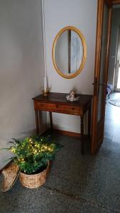 a wooden table with a mirror and a potted plant at Il nido in Marina di Massa