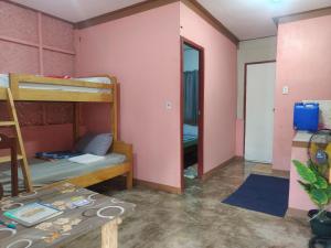 a room with bunk beds and a table in it at Beatus Residence San Isidro in New Agutaya