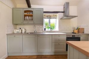 a kitchen with white cabinets and a sink at 2 Bed in Carmel oc-wai211 in Llanerchymedd
