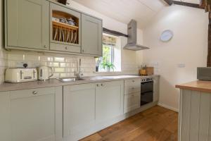 a kitchen with white cabinets and a sink at 2 Bed in Carmel oc-wai211 in Llanerchymedd