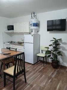 eine Küche mit einem Tisch und einem weißen Kühlschrank in der Unterkunft La isabela in Mar del Plata