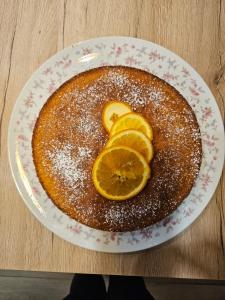 a cake with orange slices on a plate on a table at A l'ombre du mûrier in Anglure
