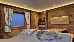 a bedroom with a bed in a room with wooden walls at Chalet Auszeit - Wohlfühlzeit Naturdesign Chalet`s in Rimbach