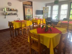 a restaurant with tables and yellow tables and chairs at Casona Rural alquiler temporal in Puerto Rico