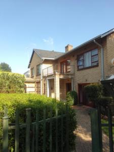 a brick house with a fence in front of it at Lens BnB Guesthouse in Benoni