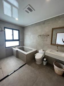a bathroom with a tub and a toilet and a sink at 蘇西好日子別墅 in Sanxing