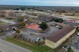 an aerial view of a small town with a parking lot at Cannon Inn By Capital O Gonzales Tx in Gonzales
