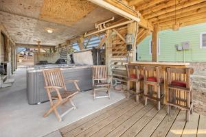 a porch with chairs and a kitchen with a stove at 6129 - Lady Jane in Nags Head