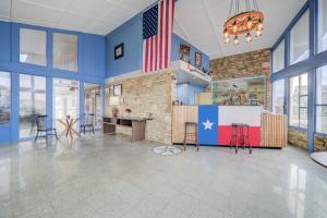 a large room with a fireplace and an american flag at Cannon Inn By Capital O Gonzales Tx in Gonzales