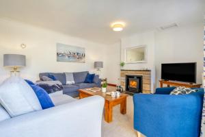 a living room with two blue couches and a fireplace at 3 Bed in Kingsbarns oc-k30925 in Kingsbarns