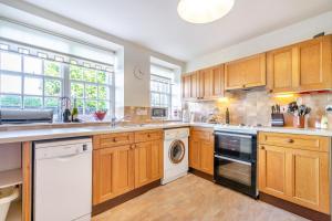 a large kitchen with wooden cabinets and a dishwasher at 3 Bed in Kingsbarns oc-k30925 in Kingsbarns