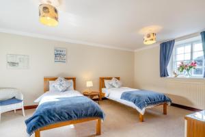a bedroom with two beds and a window at 3 Bed in Kingsbarns oc-k30925 in Kingsbarns
