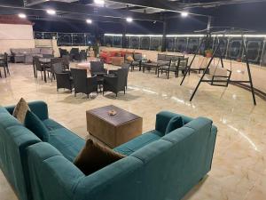 a living room with a blue couch and tables and chairs at Suzan Hotel Apartments in Amman +58 photos