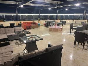 a large room with couches and tables and chairs at Suzan Hotel Apartments in Amman