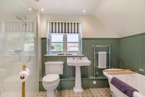 a green bathroom with a toilet and a sink at 3 Bed in Cley oc-t32433 in Cley next the Sea +28 photos