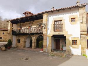 an old stone building with a balcony on it at Casona de Gómez y Terán in Renedo