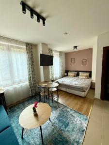 a living room with a bed and tables and a couch at Panorama Studio Home2Host in Bansko