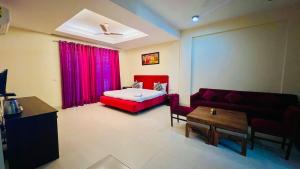 a living room with a red couch and a bed at The hotel am bliss in Gurgaon