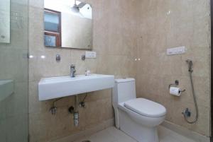 a bathroom with a sink and a toilet and a mirror at The hotel am bliss in Gurgaon