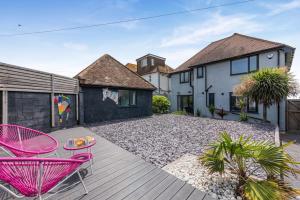 a backyard with pink chairs and a wooden deck at 4 Bed in Saltdean oc-a32366 in Saltdean