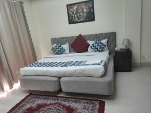 a bedroom with a bed and a couch in it at The hotel am bliss in Gurgaon