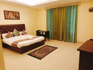 a bedroom with a bed and a window with curtains at The hotel am bliss in Gurgaon