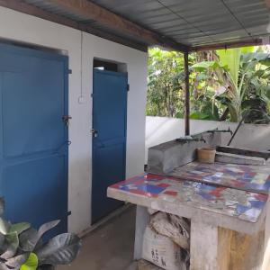 a room with a blue door and a table at Saloon lodge in Antsiranana