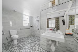a white bathroom with a sink and a toilet at Metropole Suites South Beach in Miami Beach +41 photos