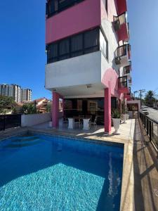 ein Schwimmbad vor einem Gebäude in der Unterkunft Hotel Rosa Mar in Macaé