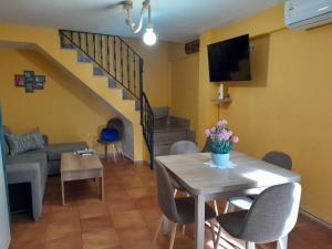 a living room with a table and a couch and stairs at La Tijera in Candeleda