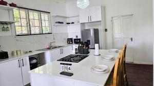 a kitchen with white cabinets and a white counter top at Jacaranda Escape in Pretoria +18 photos