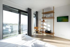 a bedroom with a bed and a tv on a wall at Maris Apartments in Egmond aan Zee