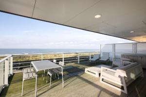a balcony with a table and chairs and the ocean at Maris Apartments in Egmond aan Zee