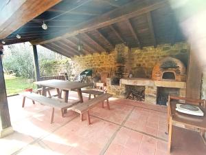 a patio with a picnic table and a brick oven at Casona de Gómez y Terán in Renedo